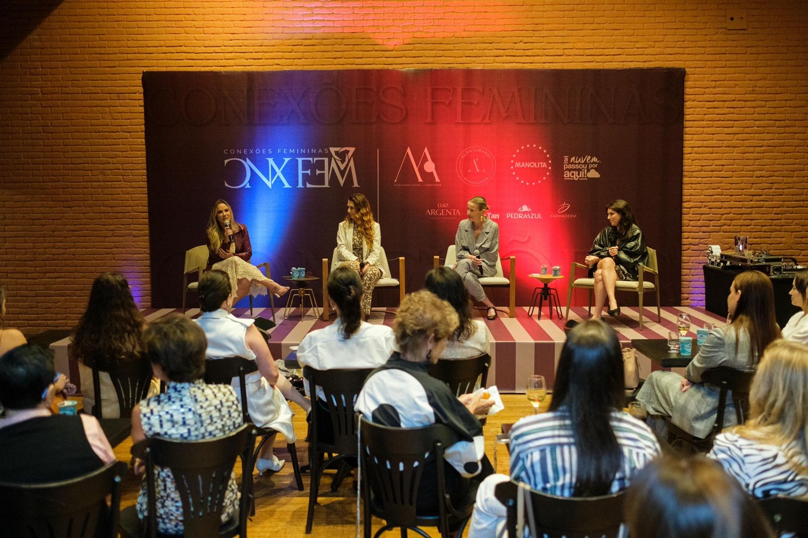 Palco com as palestrantes e as responsáveis pelo projeto